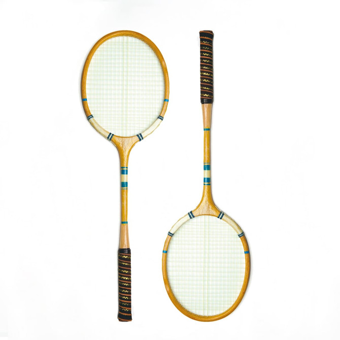 A set of two wooden badminton rackets with black grips and a light green string pattern.