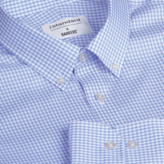 A blue and white checkered button-up shirt with a collar and branded tag. Features pearl-like buttons.