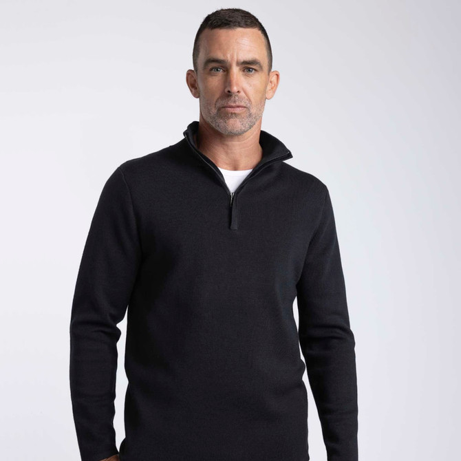 A black men's knit pullover with a zip collar and a fitted design, featuring a branding logo.