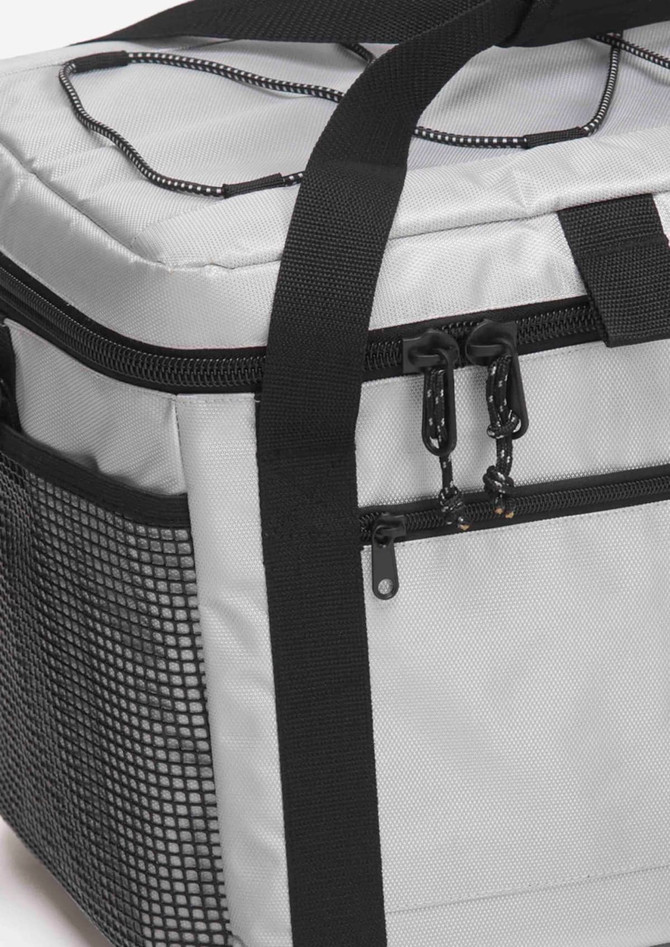 A grey cooler with a black mesh side pocket and sturdy handle, featuring zippers and straps for easy transport.