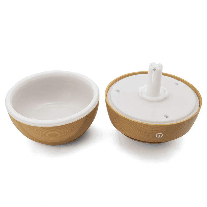 A wooden-textured diffuser with a white ceramic interior, featuring a base with a central nozzle and a logo.