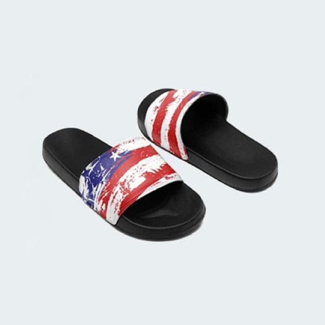 Slides featuring a red, white, and blue design with a black sole. The product includes a brand logo.