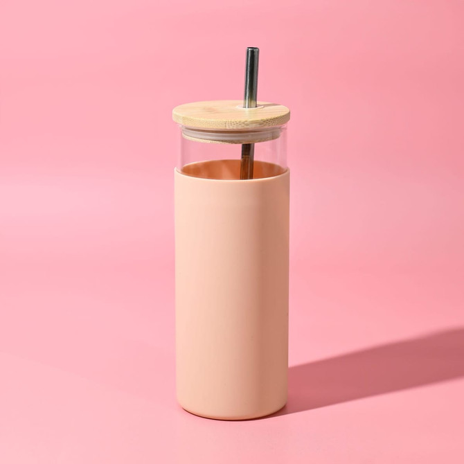 A drink bottle featuring a transparent upper section and a peachy pink outer sleeve, complete with a wooden lid and a metal straw.