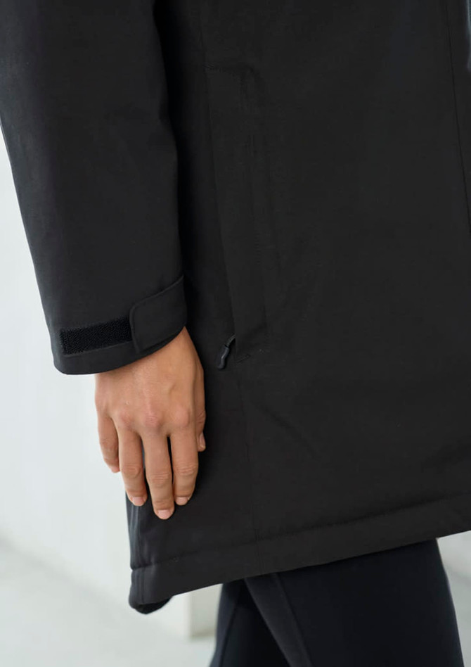 A black unisex rain jacket featuring a hand on the side pocket, with a logo on the fabric.