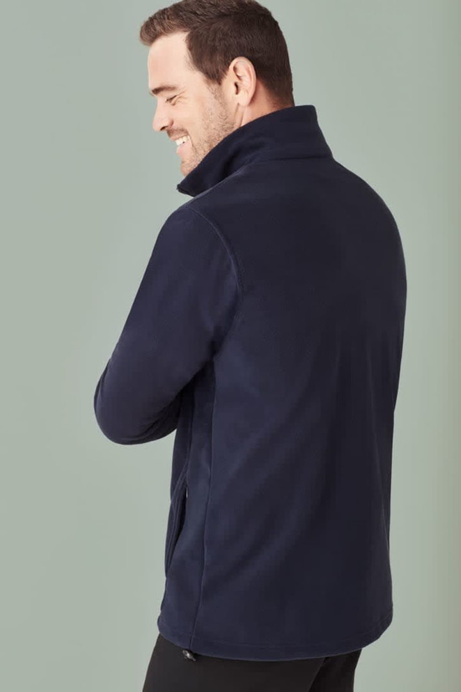 A navy micro fleece jacket for men, featuring a high collar and side pockets. The model is smiling while facing away.