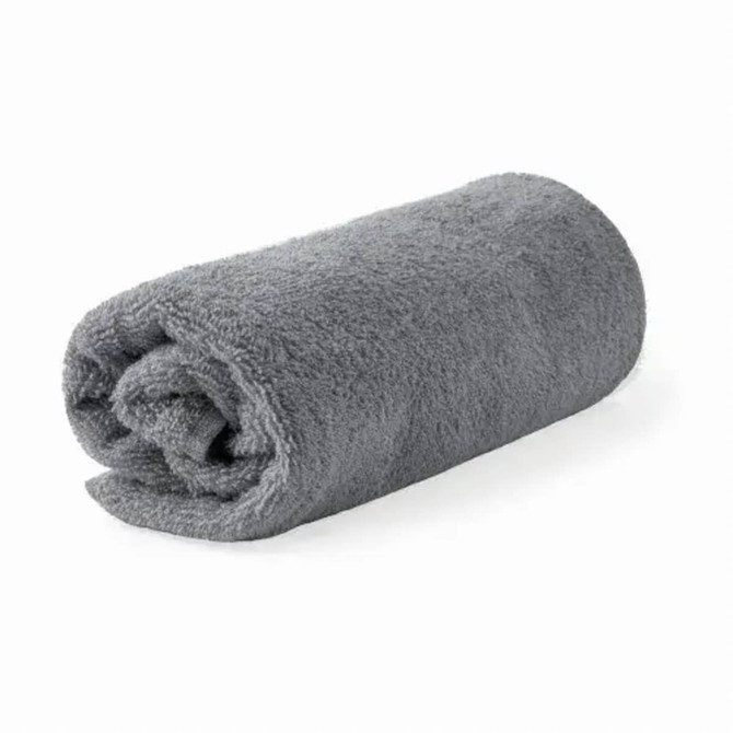 A rolled bath towel in soft grey organic cotton, featuring a simple design and a branding logo.