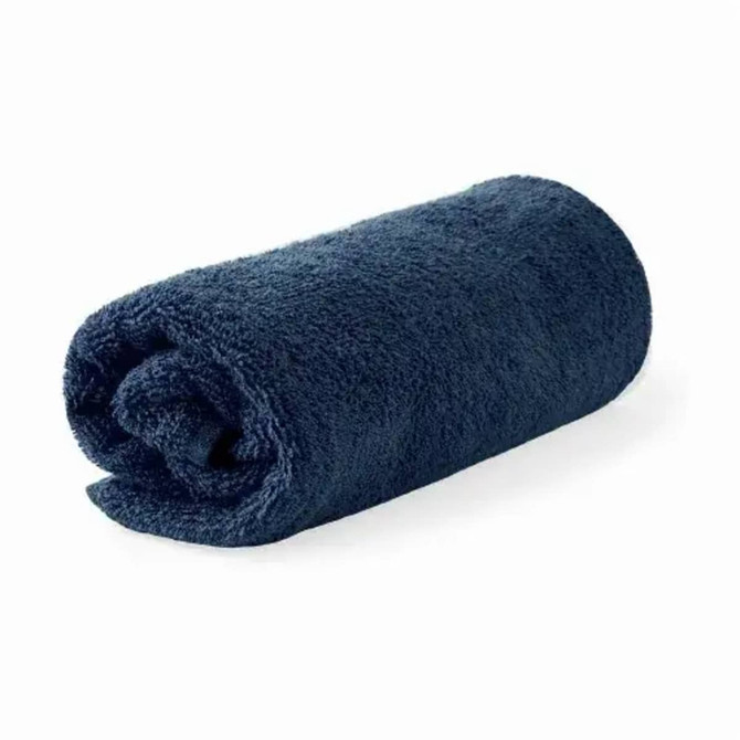 A rolled navy blue bath towel made from organic cotton, featuring a branding label.