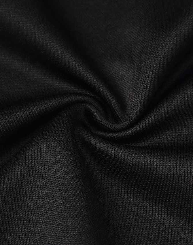 A close-up of black fabric, showcasing a smooth texture with a slight stretch, typical of polo shirt material.