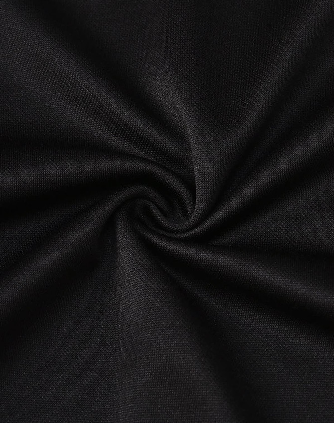 A close-up of black fabric featuring a smooth, textured surface, showcasing its sustainable poly/cotton blend.