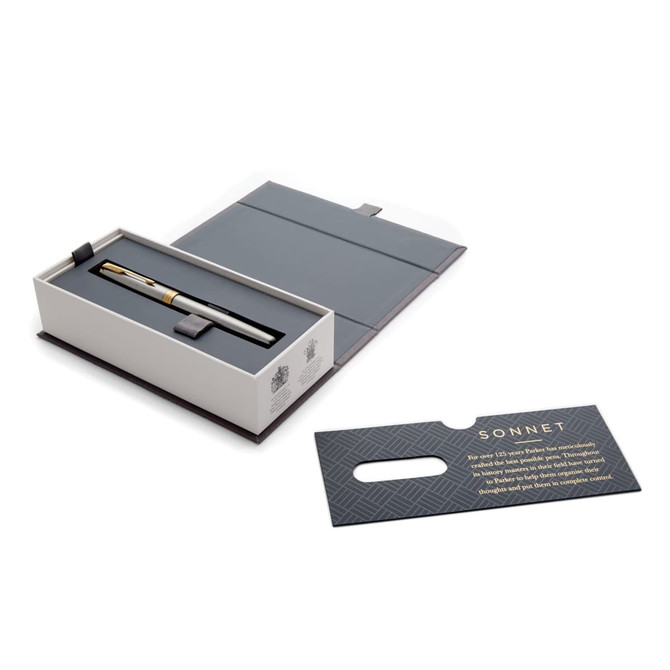 A metal rollerball pen in brushed stainless steel, presented in a grey box with a card, featuring a logo.