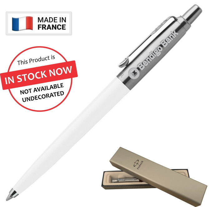 A ballpoint pen in white with a silver clip and a branded logo, presented in a gold box.