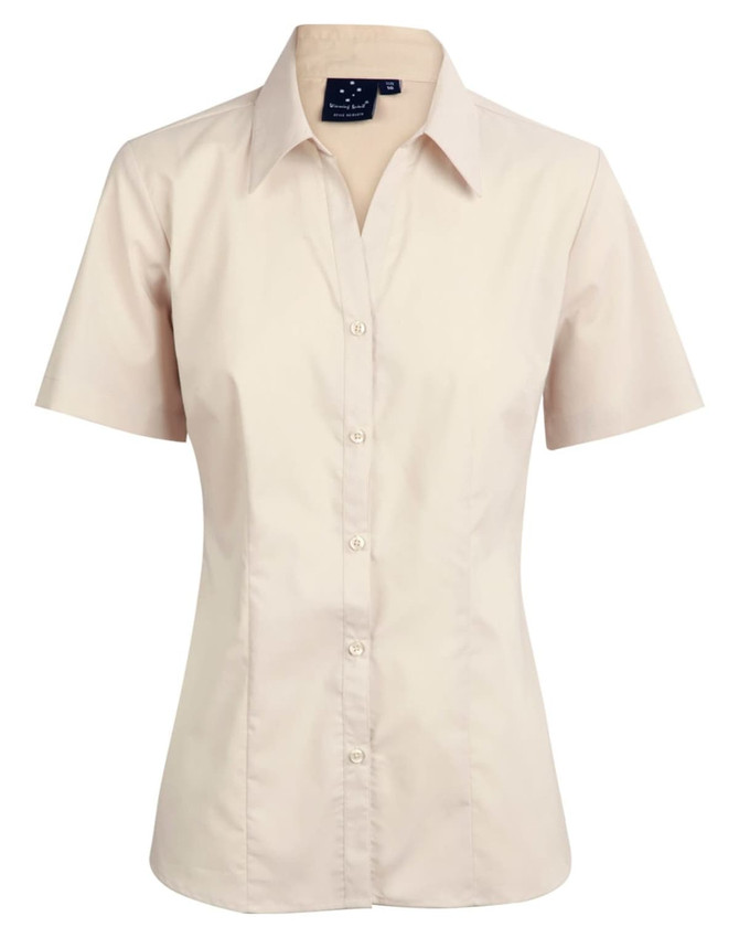 A short sleeve button-up shirt in a light beige colour, featuring a collar and a logo on the tag.