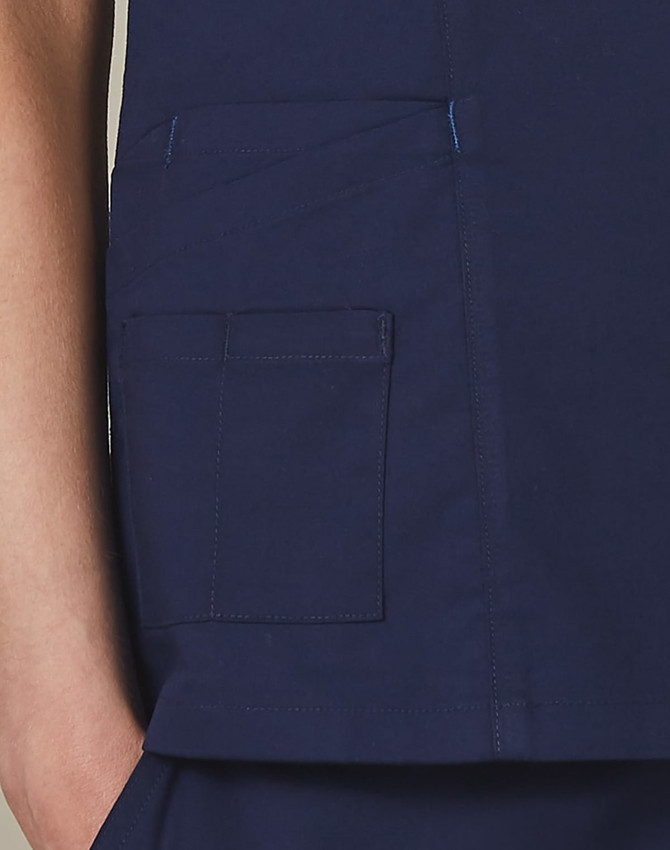 A deep navy scrub top featuring a pocket detail and contrast stitching. Includes a small logo on the garment.