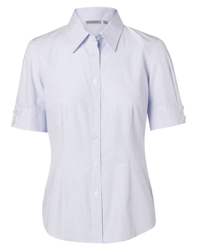 A light blue, short-sleeved women's button-up shirt with a collar and button details on the sleeves, featuring a logo.