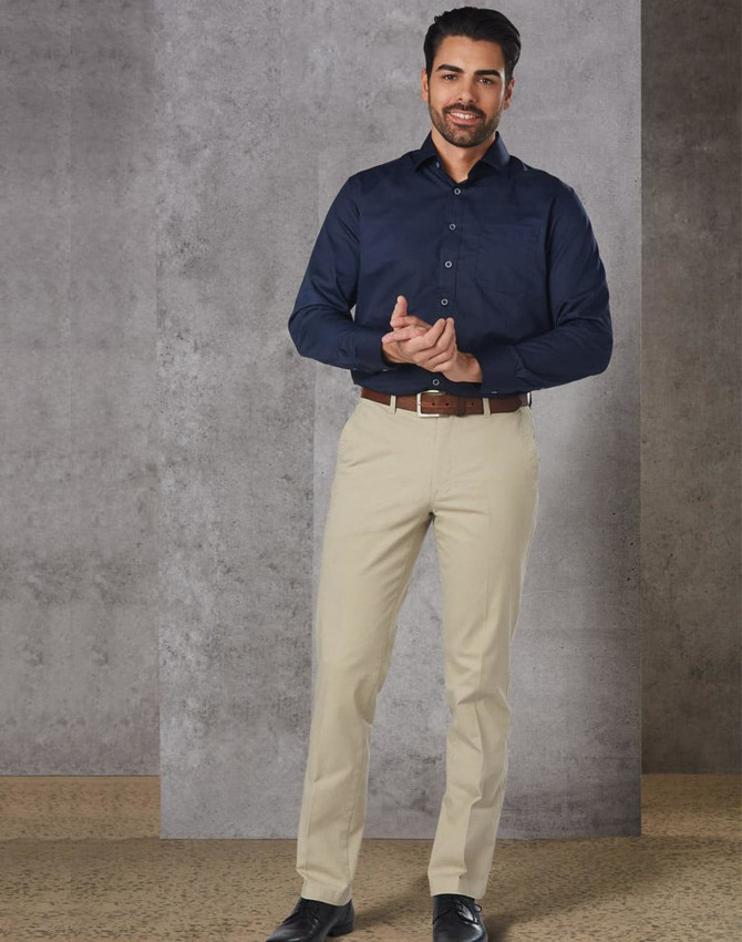 Men's chino pants in a light beige colour, displayed with a navy button-up shirt and brown belt. Features branding on the waistband.