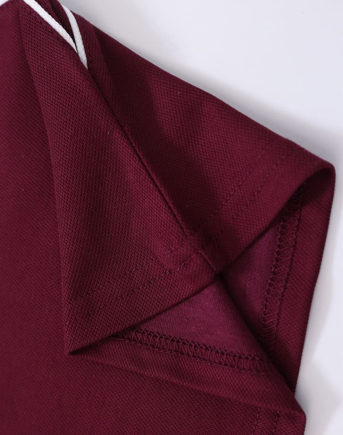 A maroon men's polo shirt featuring a folded collar and sleeve with a textured fabric. Brand logo visible.