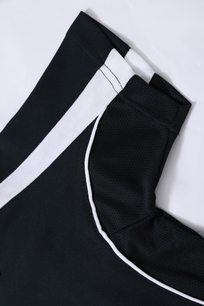 A black polo shirt featuring white accents and a logo at the collar. The fabric appears textured.