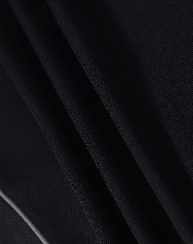 A close-up of black fabric, showcasing the texture and weave of a polo shirt. The fabric appears lightweight and breathable.