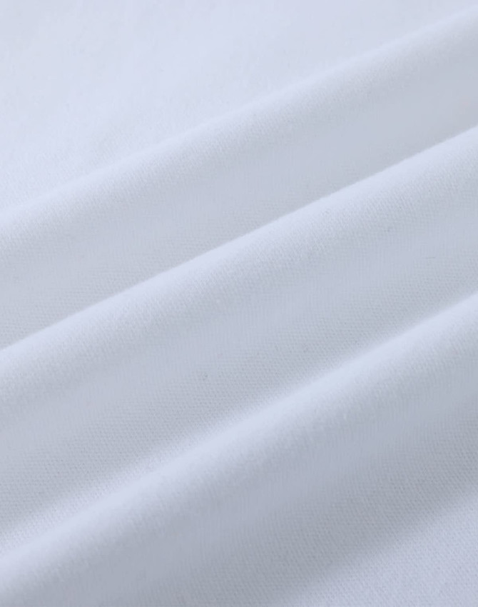 A close-up of white cotton fabric with soft, smooth texture, featuring natural wrinkles and folds.