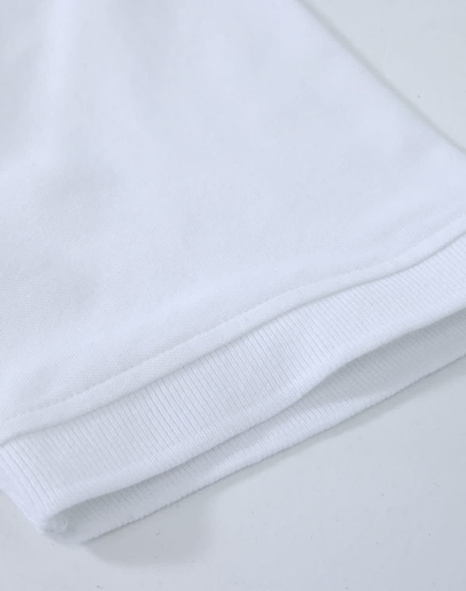 A close-up of a white cotton stretch polo shirt, showcasing the fabric and hem details. The shirt has a logo.