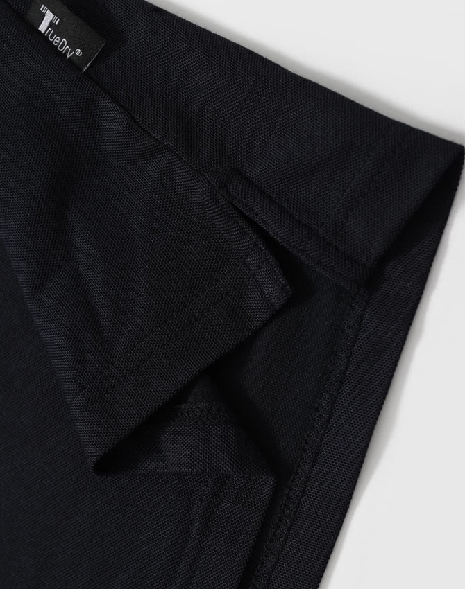 A black polo shirt with a short collar and branded tag detailing at the neckline.
