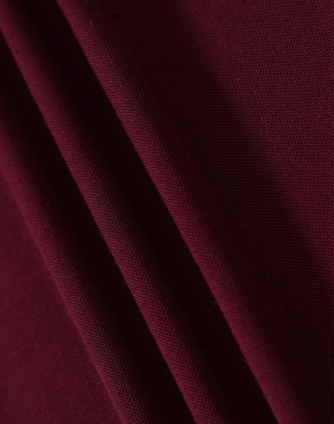 A close-up of maroon fabric, showing a textured weave with draped folds.