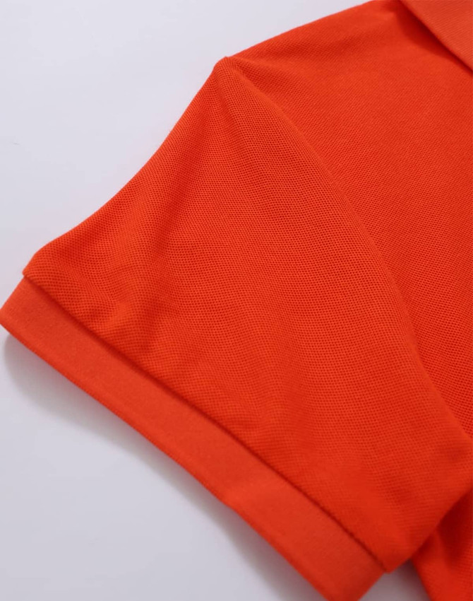 An orange polo shirt featuring a folded collar and short sleeves, with a logo on the chest area.