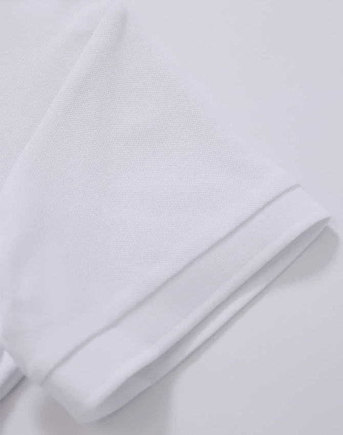 A white polo shirt featuring a textured fabric and a folded sleeve detail. It includes a logo.