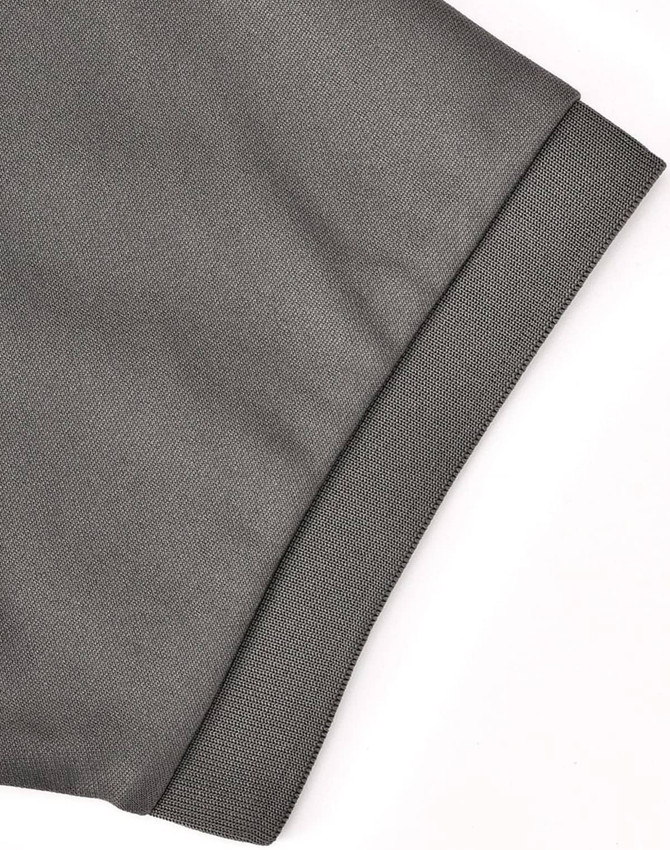 A close-up of the cuff of a grey sustainable poly/cotton polo shirt, featuring a textured fabric and an edge detail.