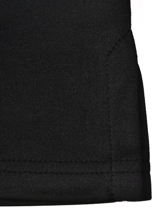 A close-up of a black sustainable poly/cotton polo shirt, featuring a neatly finished hem and a tag on the fabric.
