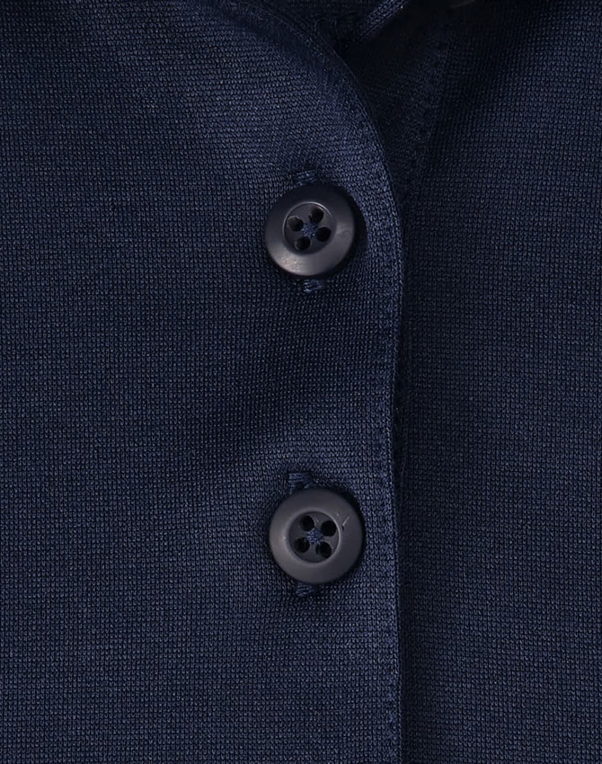 Close-up of a navy blue polo shirt featuring a button placket and a logo.