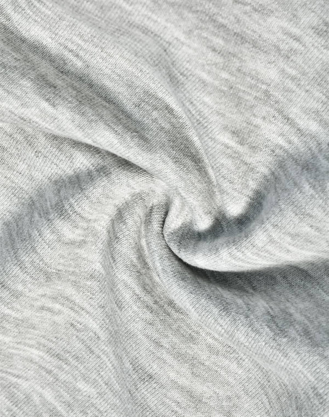 A close-up of light grey fabric, showcasing the soft texture of poly/cotton terry.