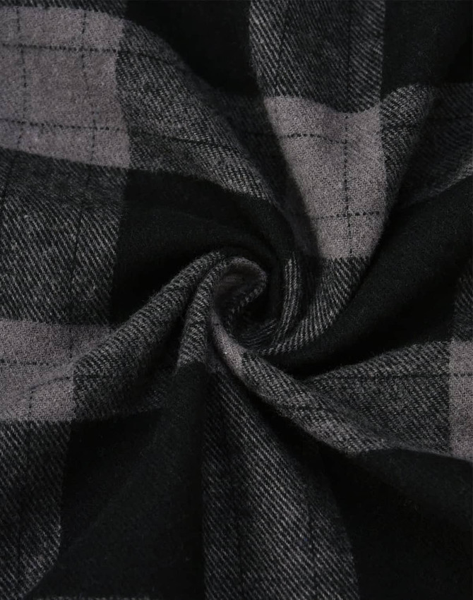 A close-up of black and grey flannel fabric featuring a plaid pattern, showcasing the texture and design.