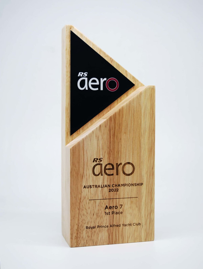 A wooden trophy with a matte black alloy accent, featuring a triangular design. It includes a logo and engraved text.