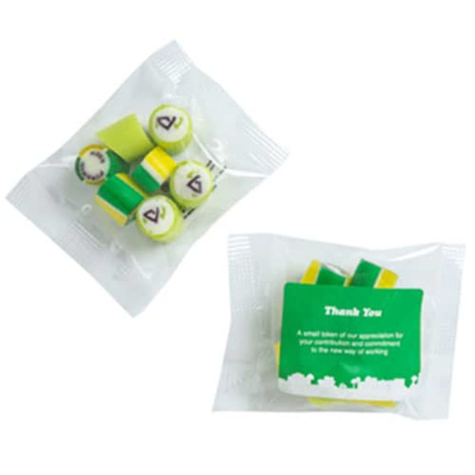 A bag of assorted rock candy pieces in green and yellow, with a branded sticker attached.