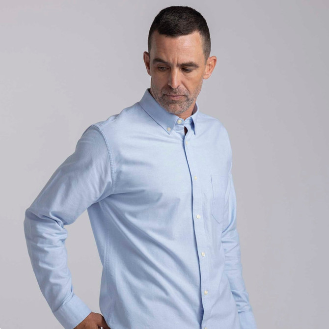 A light blue button-up shirt for men, featuring a collar and a chest pocket, with a logo on it.