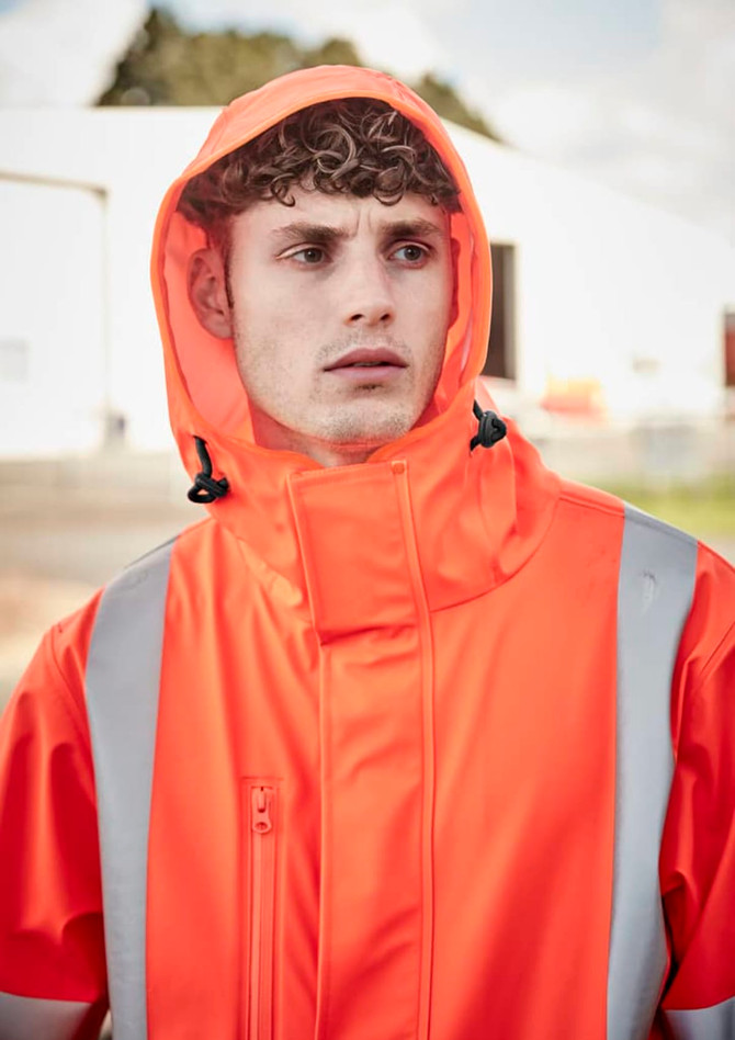 An orange heavy-duty waterproof jacket with reflective strips, featuring a hood and a zippered collar, worn by a model.