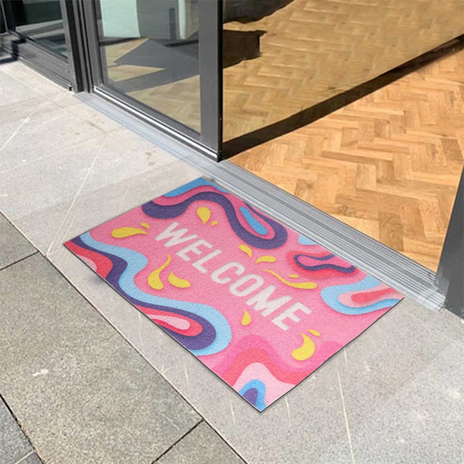 A colourful mat with a swirling pattern and a welcoming design, placed at an entrance.