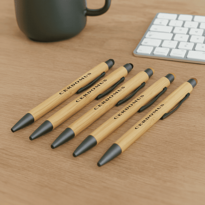 A set of bamboo pens in natural wood and black, featuring a logo, displayed on a wooden surface.