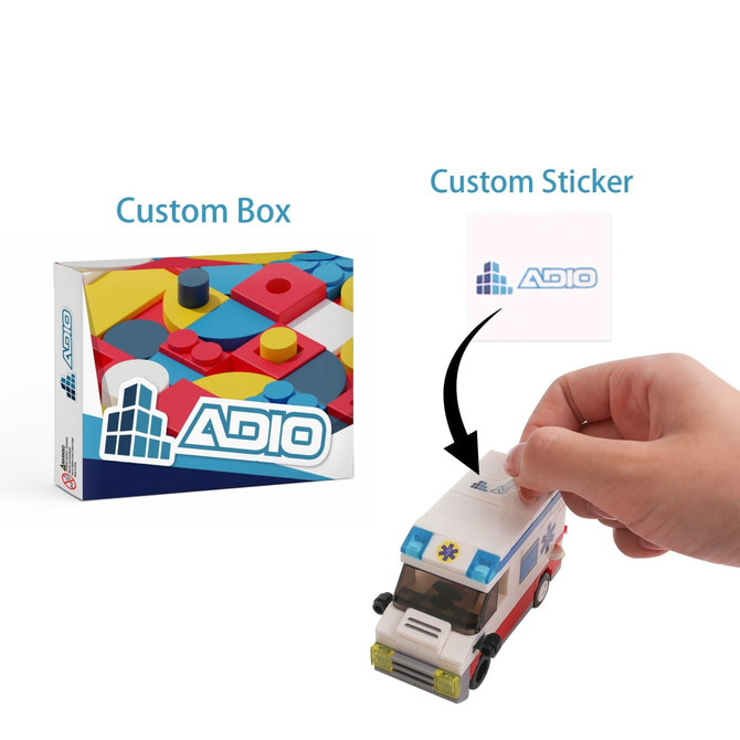 Building blocks set in a colourful box featuring a toy ambulance and a hand applying a custom sticker.