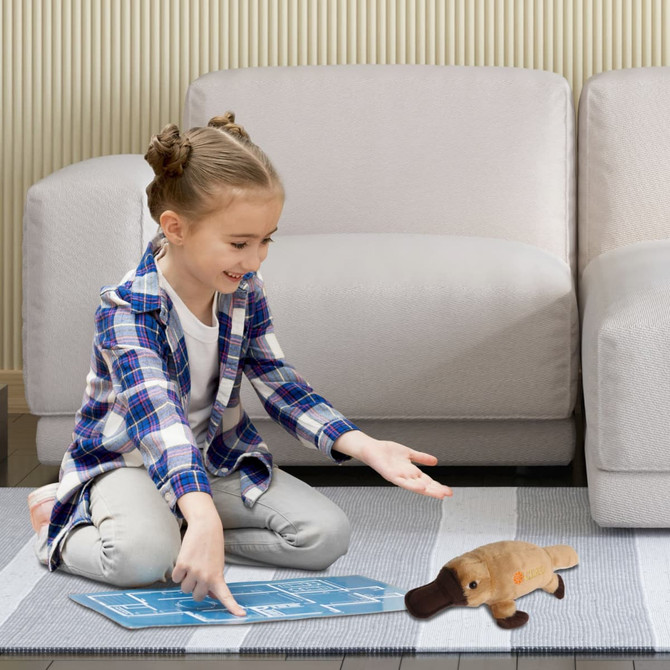 A plush platypus toy in brown and beige, with a child playing on a rug in a modern living room setting.