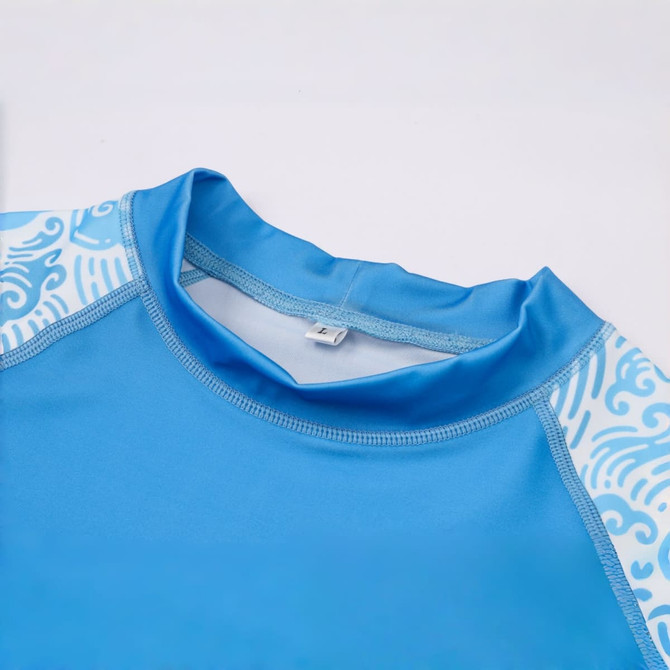 A blue rashie featuring short sleeves, with decorative patterns along the shoulders and a crew neck design.