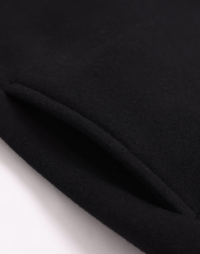 A close-up of a black polar fleece jumper featuring a 1/2 zip collar, with a smooth texture and a visible seam.