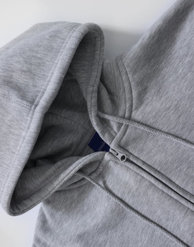 A grey men's full-zip fleecy hoodie with a hood and zippered front. It features a branding logo.