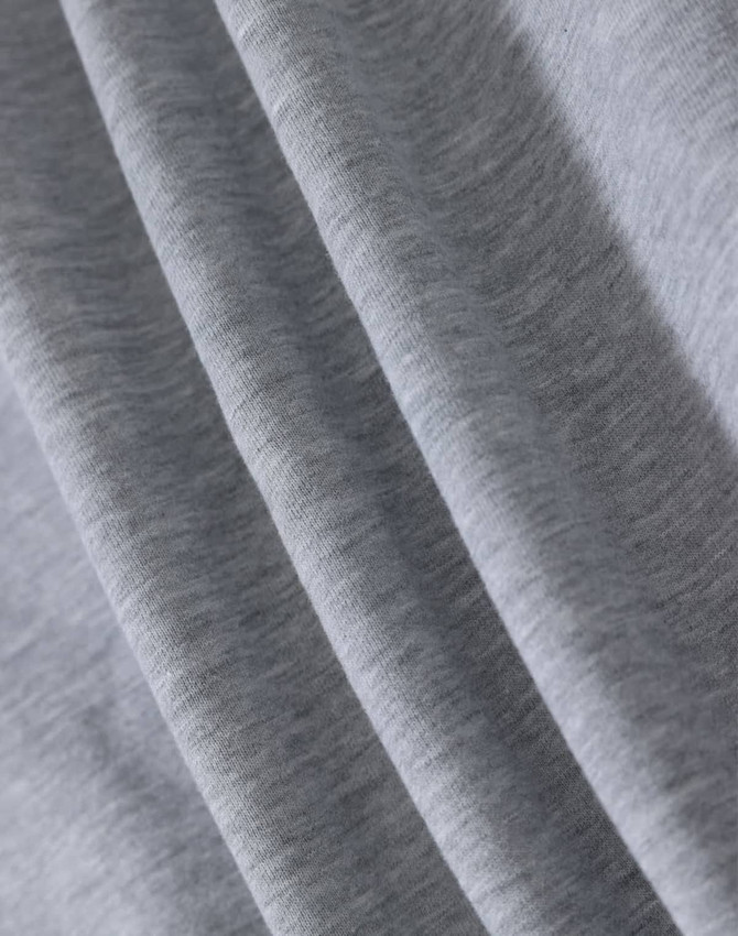 A close-up of light grey fabric, showcasing the soft texture of a fleecy material.