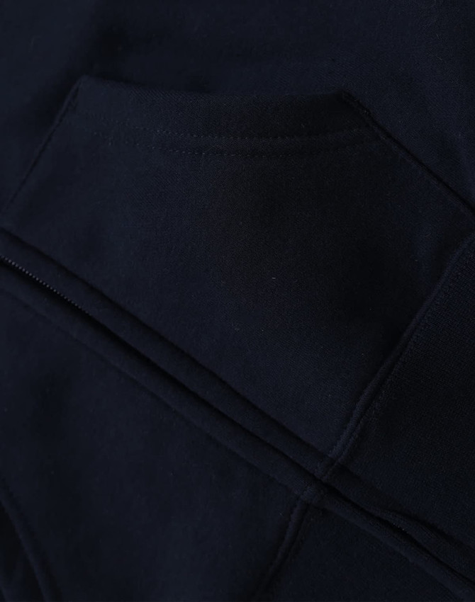 A close-up of a navy blue kid's full-zip fleecy hoodie featuring a kangaroo pocket and a logo.