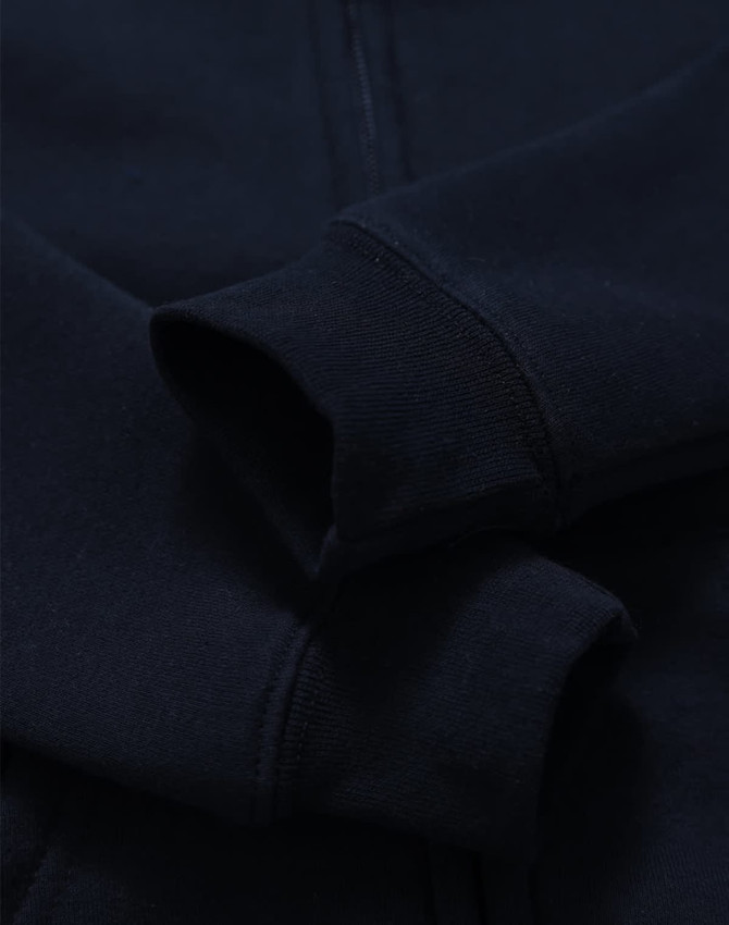 A navy blue kid's full-zip fleecy hoodie with a soft texture and cuffed sleeves. Features a logo.