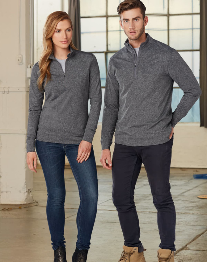 A grey ladies' half zip long sleeve sweat top featured on a model, styled with jeans in an industrial setting.