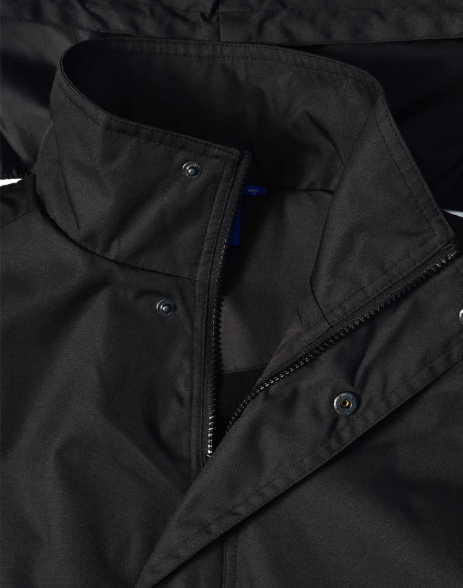 A black Long Line Stadium Jacket with a zip and snap closures, featuring a collar and logo branding.