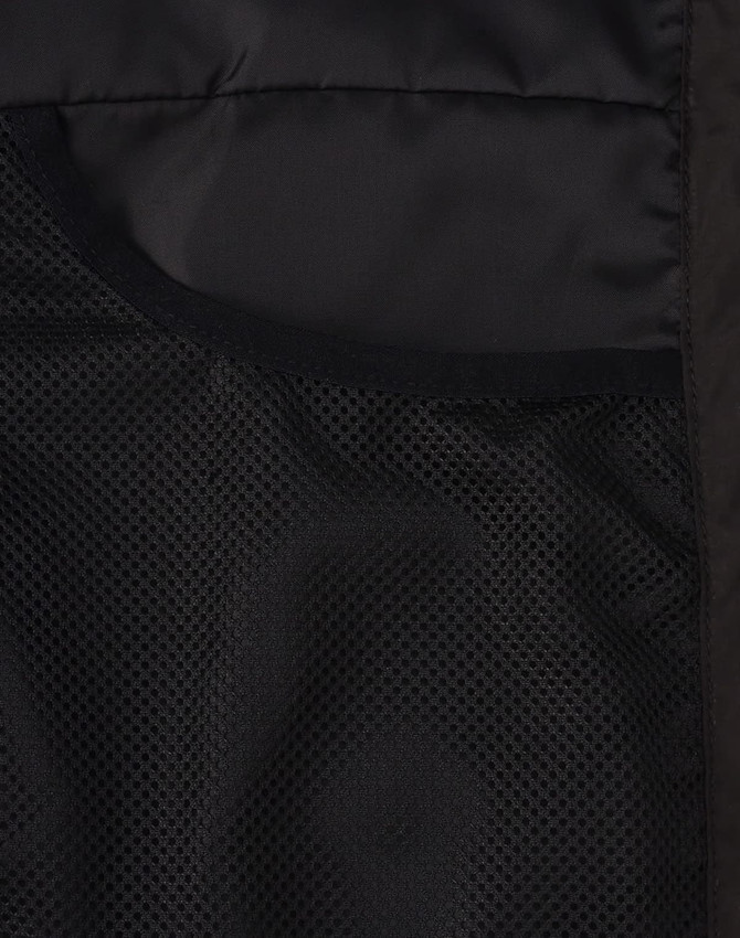 A close-up of the interior of a black insulated puffer jacket, featuring mesh pockets.
